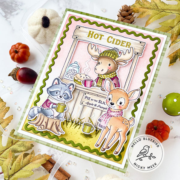 Card with woodland animals enjoying hot cider, surrounded by autumn decorations.